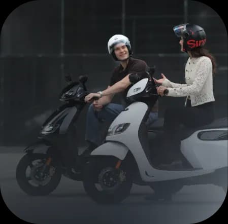 A rider travelling through the city on a white scooter
